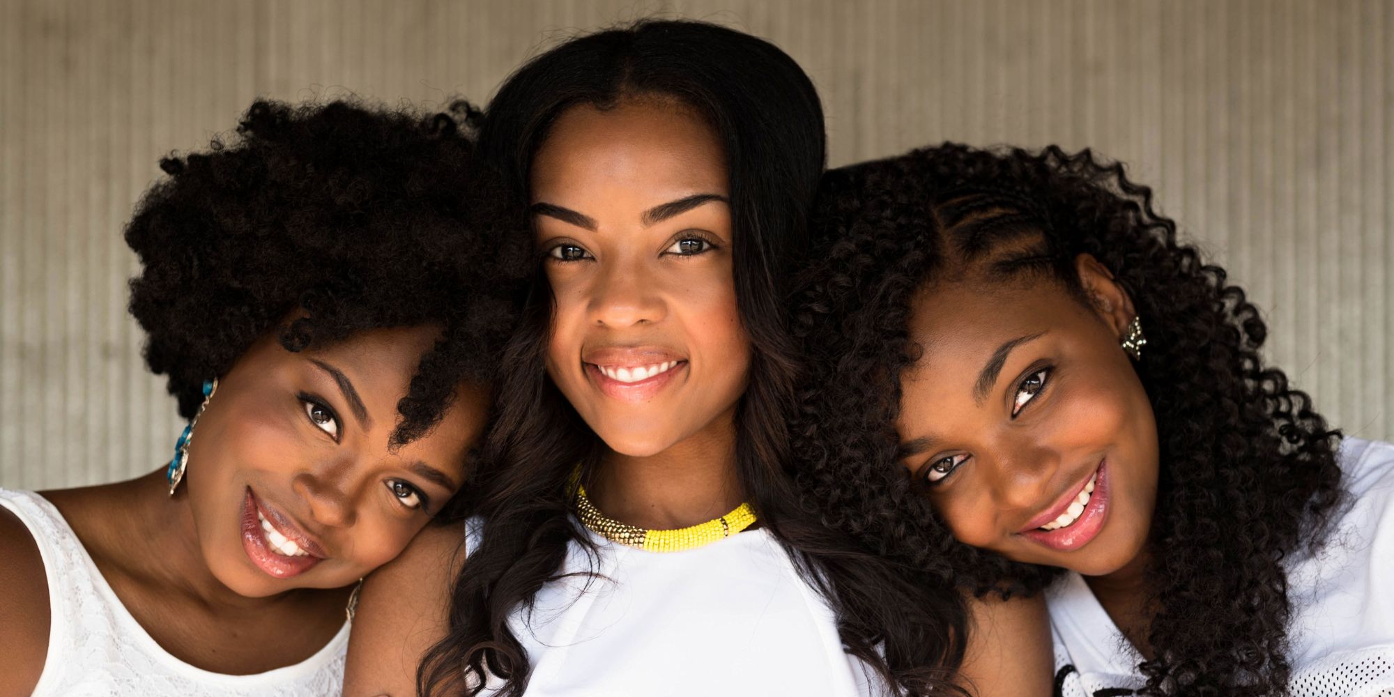 Three black women looking forward and smiling